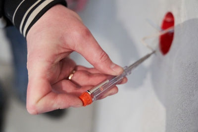 Midsection of man holding thermometer