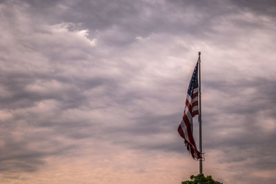 Low angle view of flag against cloudy sky