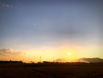 Scenic view of field against sky during sunset