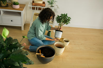 Portrait of woman holding potted plant