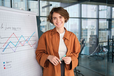 Portrait of young woman standing in city