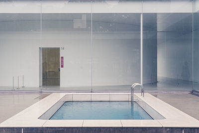 Empty swimming pool against building