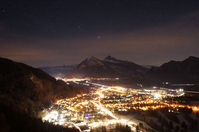 Aerial view of illuminated buildings against sky at night