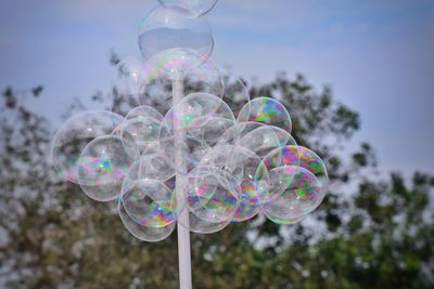 Low angle view of bubbles against rainbow in sky