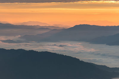 Scenic view of silhouette mountains against romantic sky at sunset