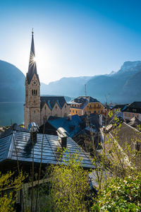 Church by buildings against blue sky