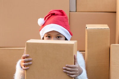 Portrait of boy holding hat in box at home