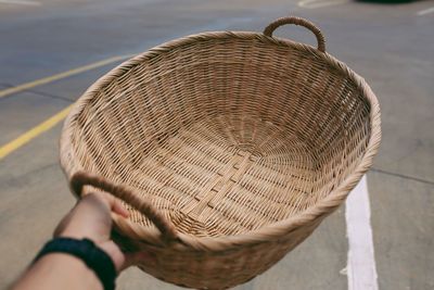 Cropped hand holding basket over road