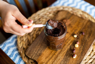 Close-up of hand holding ice cream cone on table