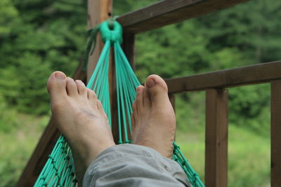 Low section of person relaxing on hammock