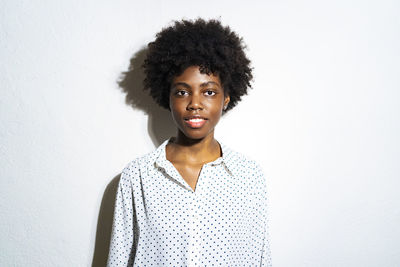 Curly hair woman staring while standing against white background