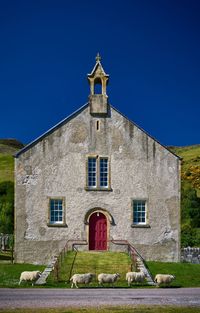 Low angle view of building against clear blue sky