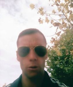 Portrait of young man wearing sunglasses against sky