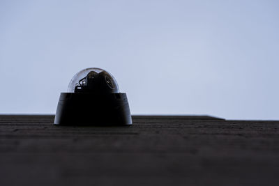 Close-up of camera on table against clear sky