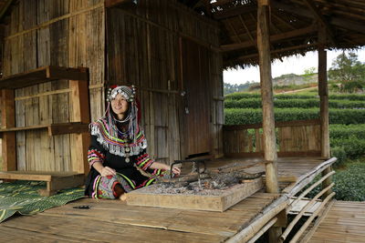 Portrait of woman sitting on wood
