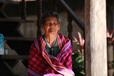 Portrait of senior woman against staircase