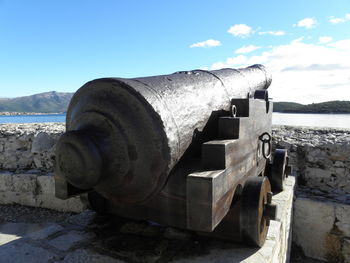 Close-up of metal by sea against sky