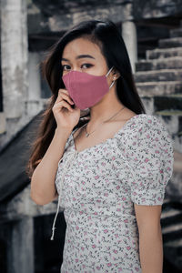 Portrait of beautiful young woman standing outdoors