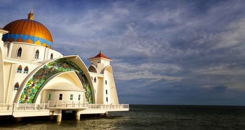 Temple by sea against sky