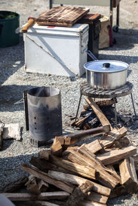 High angle view of firewood by saucepan on metal grate at campsite