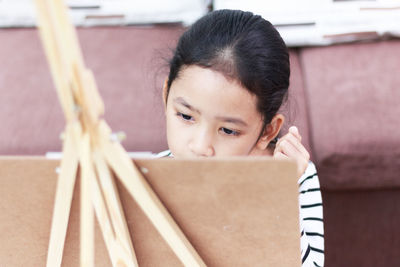Close-up of girl painting on easel
