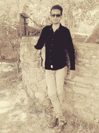 Portrait of young man standing against wall