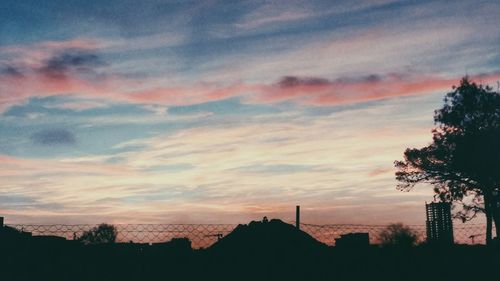 Silhouette of trees against dramatic sky