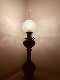 Close-up of light bulb on table against wall