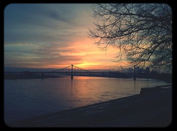 Bridge over river at sunset