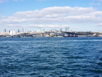 Scenic view of sea and cityscape against sky