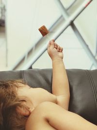 Midsection of woman resting on sofa at home