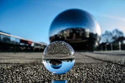 Close-up of crystal ball against blue sky