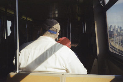 Rear view of man sitting in train