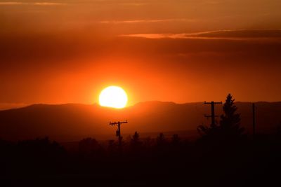 Scenic view of silhouette mountains against orange sky