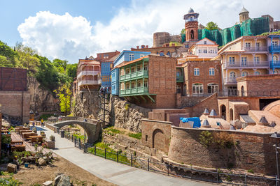 Buildings in town against cloudy sky