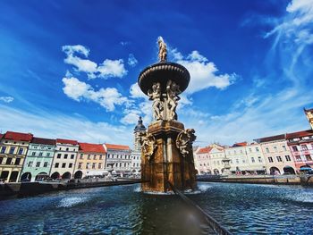 Statue of buildings in city against sky