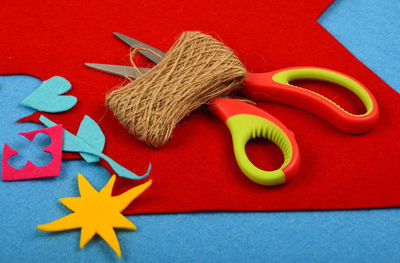 High angle view of scissor with multi colored craft papers on table