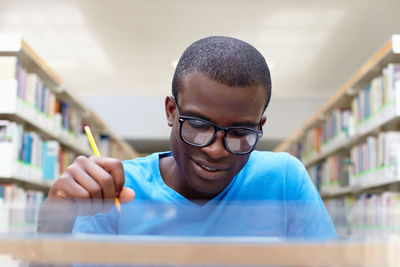 Close-up of man studying while sitting in library