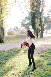 Side view of young woman standing on field