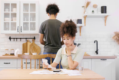 Side view of young woman sitting at home