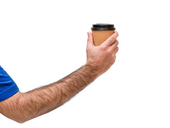 Close-up of hand holding drink against white background