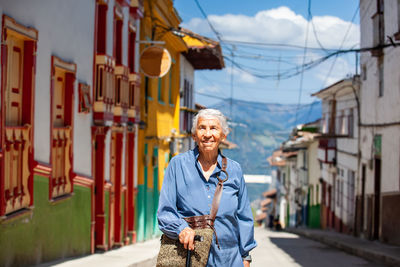 Young woman standing against buildings