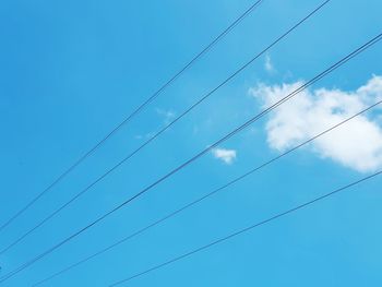 Low angle view of power cables against sky