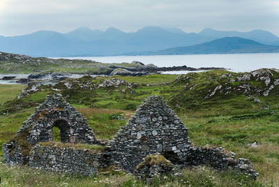 Old ruins by mountains against sky