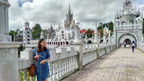 Woman standing outside temple against sky