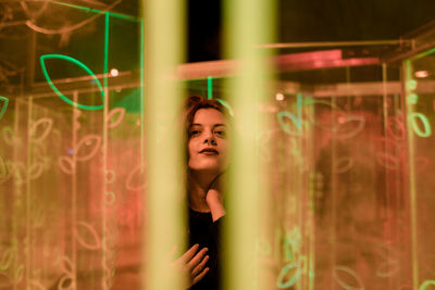 Woman standing by window at night