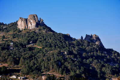 Low angle view of rock formation against clear blue sky