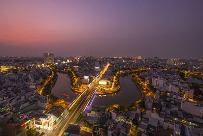 High angle view of illuminated city against sky at dusk