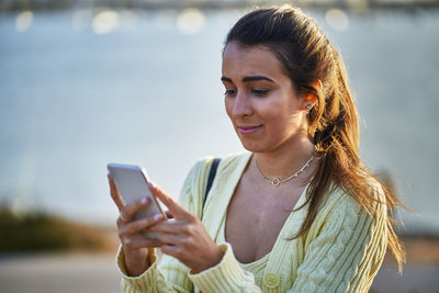 Young woman using mobile phone outdoors