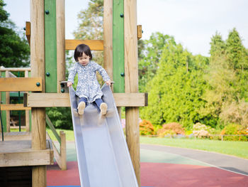 Girl playing on slide in playground
